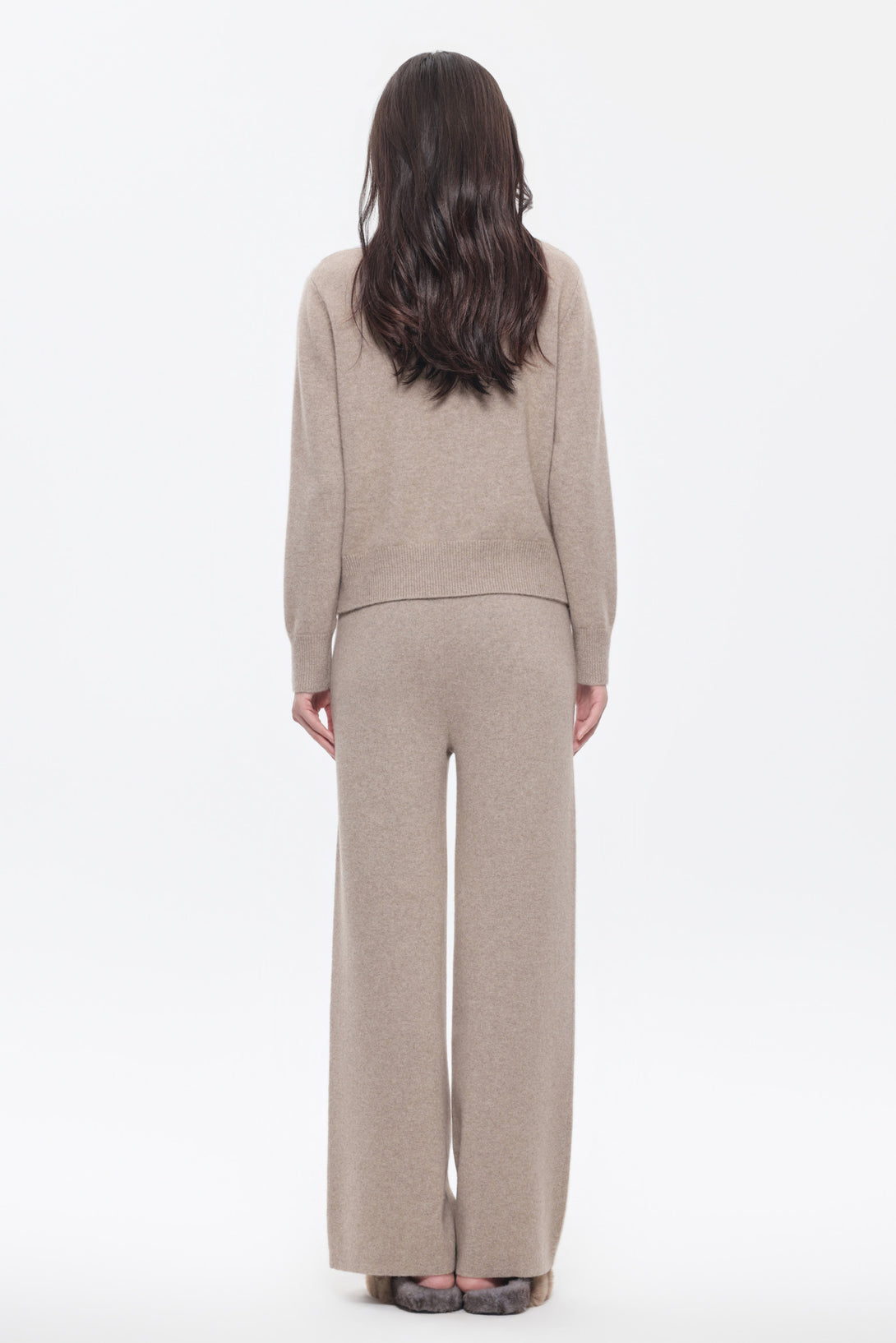 Woman wearing a beige twist pattern cashmere sweater with matching wide-leg pants from Amoer couture